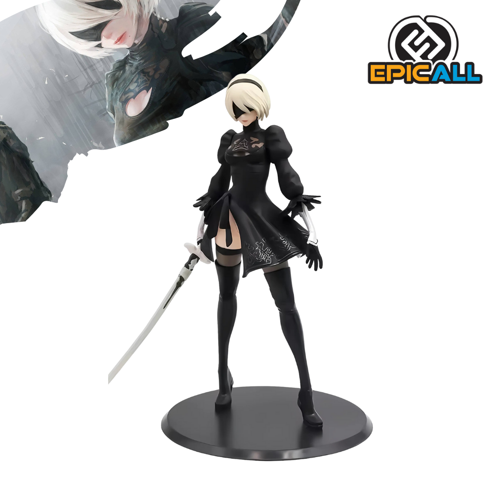 Una figura de acción de 2B, un personaje del videojuego Nier Automata. 2B es una androide femenina con cabello corto y blanco, vestida con un traje negro y blanco. Lleva una espada y tiene una expresión seria. La figura está colocada sobre una base negra.