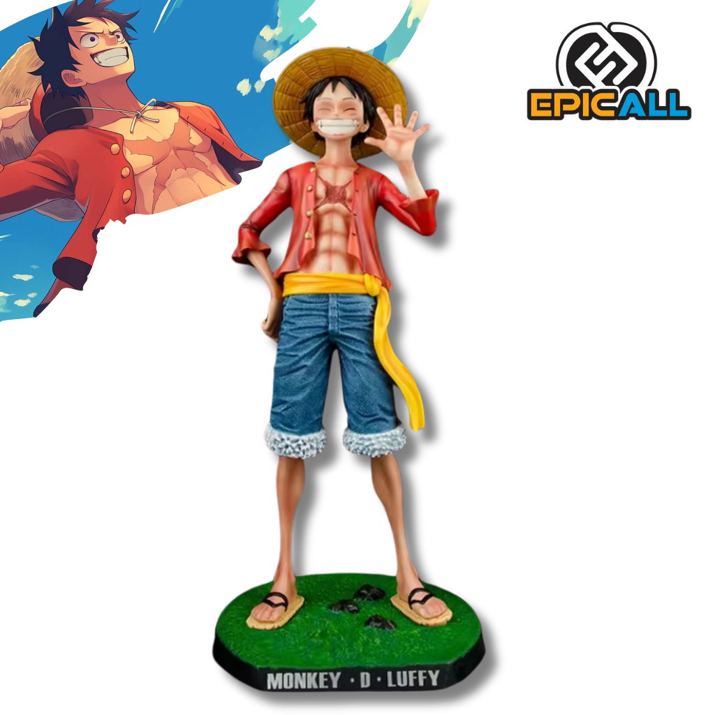 Una figura estatua grande de Monkey D. Luffy de One Piece, midiendo 42cm de altura. Luffy está sonriendo, con su característico sombrero de paja, chaleco rojo abierto, pantalones cortos azules y una banda amarilla alrededor de la cintura. Está de pie sobre una base verde con rocas.