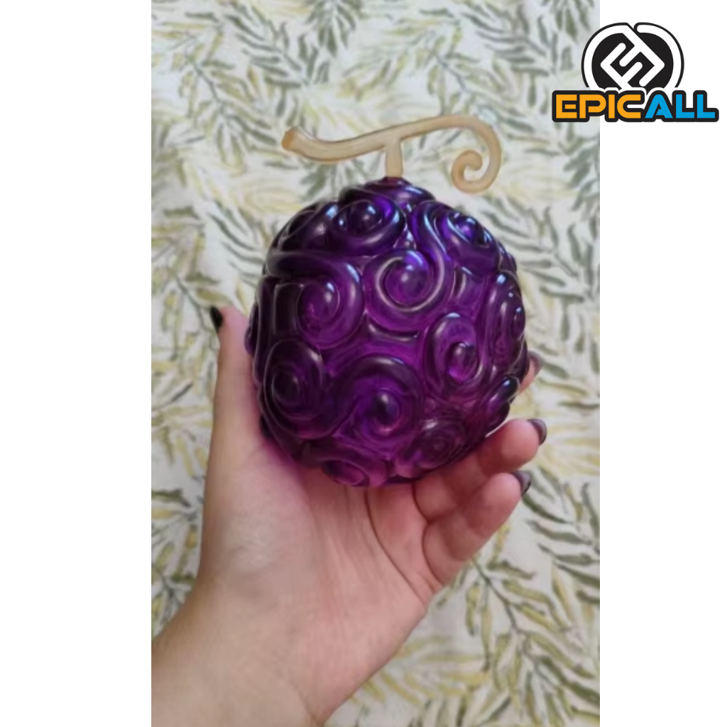 Una réplica de la Fruta del Diablo Gomu Gomu no Mi de One Piece. Es una fruta de color púrpura con un tallo dorado y una textura rugosa.