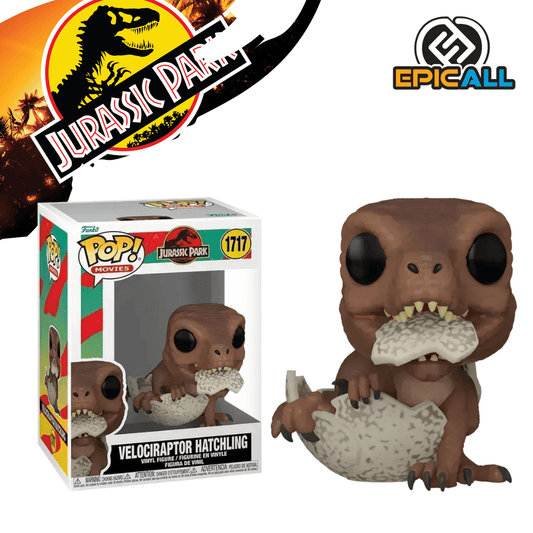 Un Funko POP de un bebé Velociraptor emergiendo de un cascarón de huevo. El dinosaurio es de color verde grisáceo, con pequeños ojos negros y una boca ligeramente abierta. Parte del cascarón de huevo blanco y texturizado lo rodea en la parte inferior. La figura tiene los ojos grandes y redondos, característicos de los Funko POP. La caja del Funko POP se ve detrás de la figura.