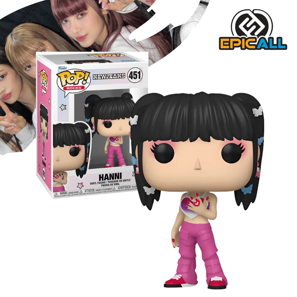 Un Funko POP de Hanni de NewJeans. La figura tiene el pelo negro recogido en dos moños con lazos blancos, un top corto blanco con un corazón rosa y pantalones rosas. Tiene los ojos grandes y redondos, característicos de los Funko POP. La caja del Funko POP se ve detrás de la figura.