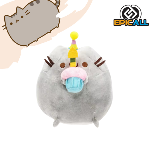Un peluche de un gato gris llamado Pusheen. Está sentado y sosteniendo un cupcake con una vela encendida. Tiene una expresión feliz y está rodeado de corazones.