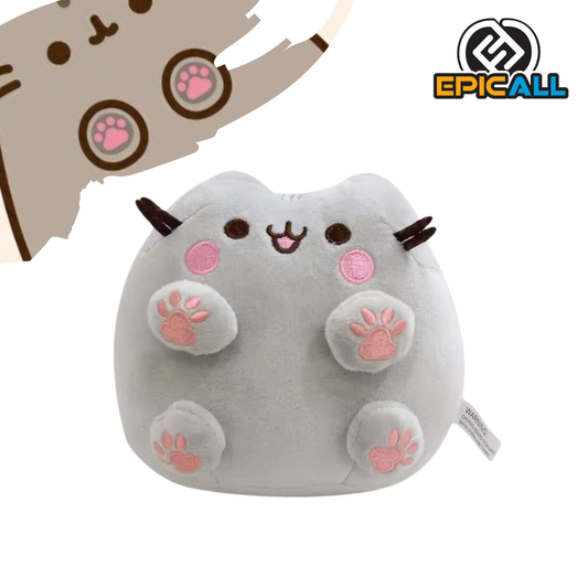 Un peluche de Pusheen, el famoso gato de internet. Pusheen es de color gris, tiene grandes ojos negros y una expresión tierna. Está sentado con sus patitas hacia afuera, que son de color rosa.