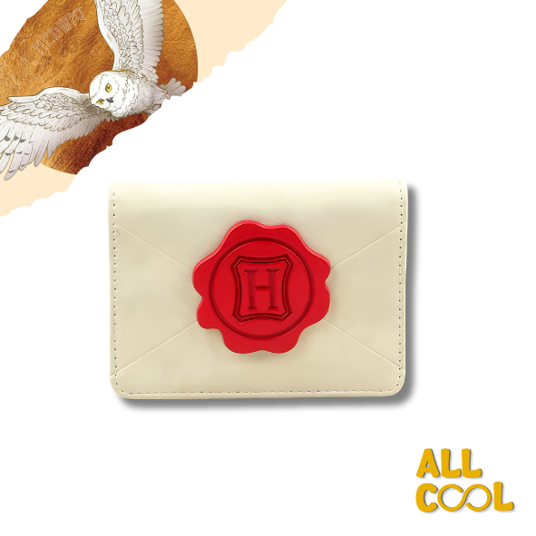 Un tarjetero con diseño inspirado en la carta de admisión a Hogwarts. El tarjetero es de color crema con detalles en rojo y tiene el sello de Hogwarts en la parte frontal.