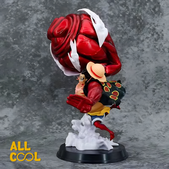 Estatua de un personaje de anime, Luffy, en una pose de lucha. Tiene un brazo gigante y musculoso de color rojo. La estatua está sobre una base circular y mide 30 centímetros de alto.