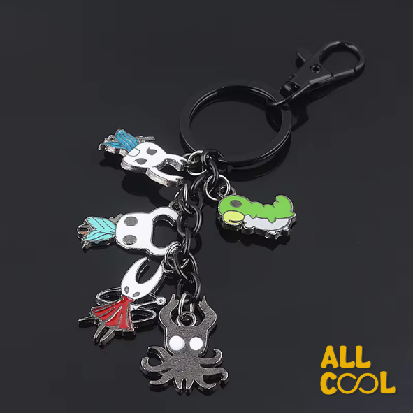 Un llavero de metal con múltiples dijes colgantes. Los dijes representan a varios personajes del videojuego Hollow Knight, incluyendo al Caballero, Hornet y el Gusano Vidente. Los dijes son de diferentes tamaños y están conectados a un anillo principal.