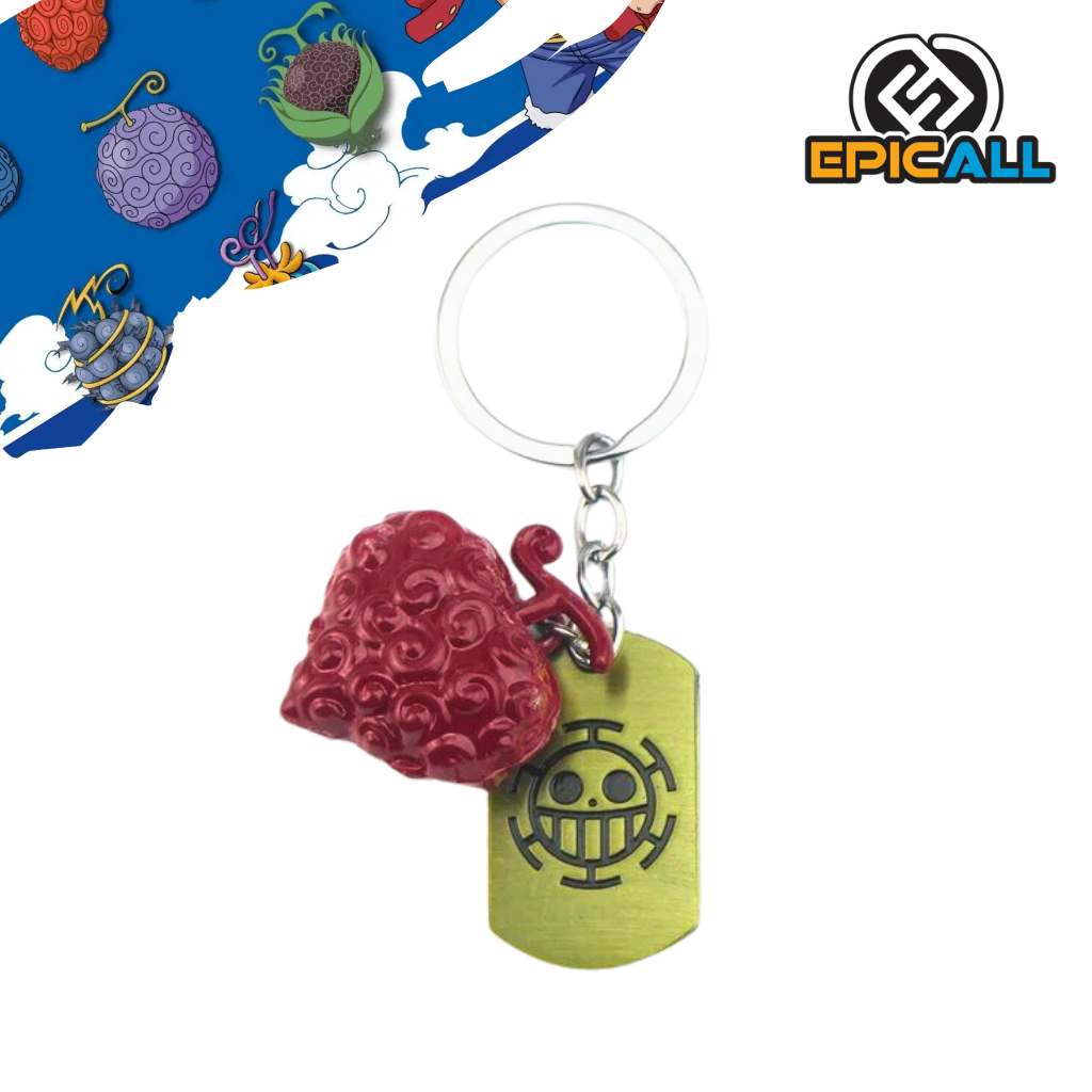 Un llavero con forma de la Fruta Ope Ope, una fruta del diablo del anime One Piece. La fruta es de color rojo y tiene una forma redondeada. El llavero incluye un colgante adicional con el símbolo del sombrero de paja de Luffy.