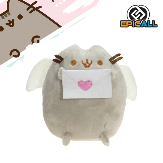 Un peluche de Pusheen, el famoso gato de internet, disfrazado de ángel. Pusheen es de color gris, tiene alas blancas y está sosteniendo una carta de amor con un corazón rosa. Tiene una expresión tierna y está sentado.