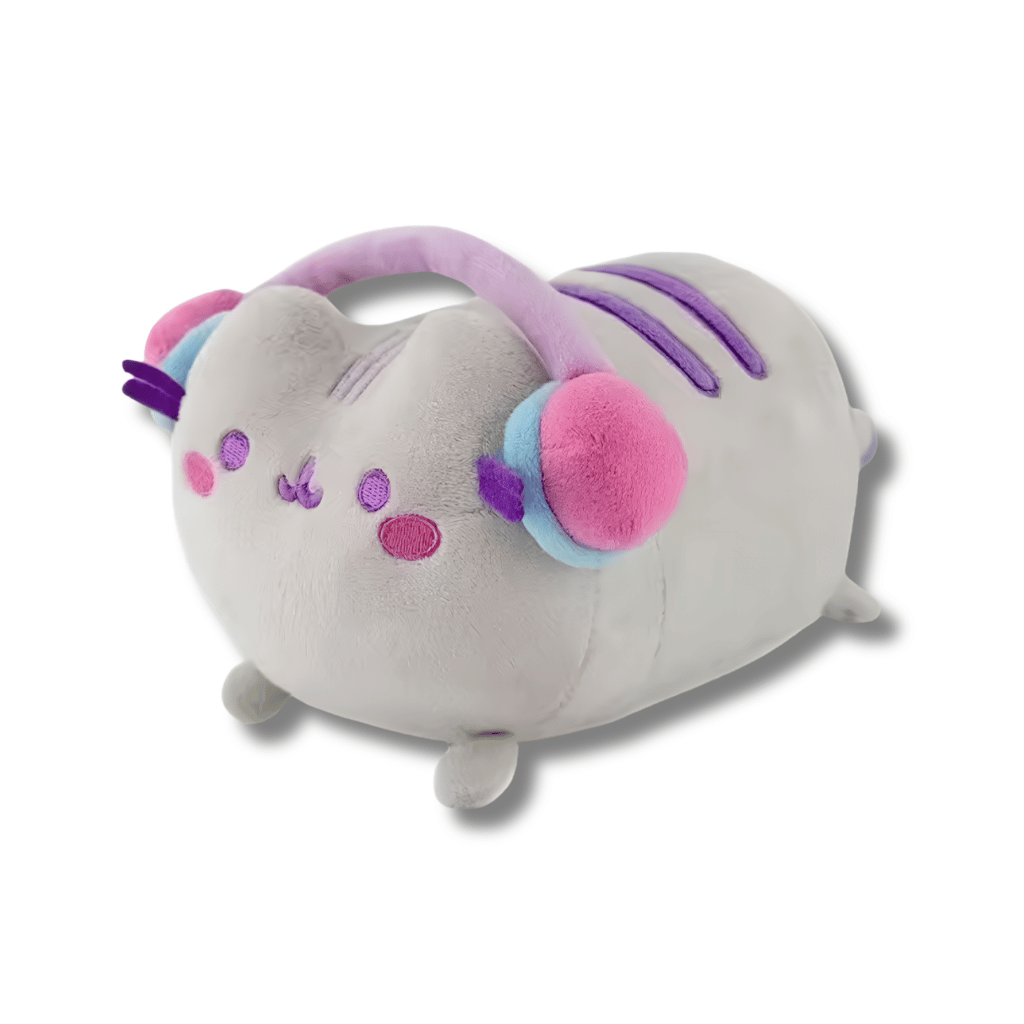Peluche suave y acolchado de Pusheen el gato en color gris claro, acostado boca abajo, luciendo unos audífonos de diadema color morado y rosado con orejeras grandes y detalles bordados en el rostro.