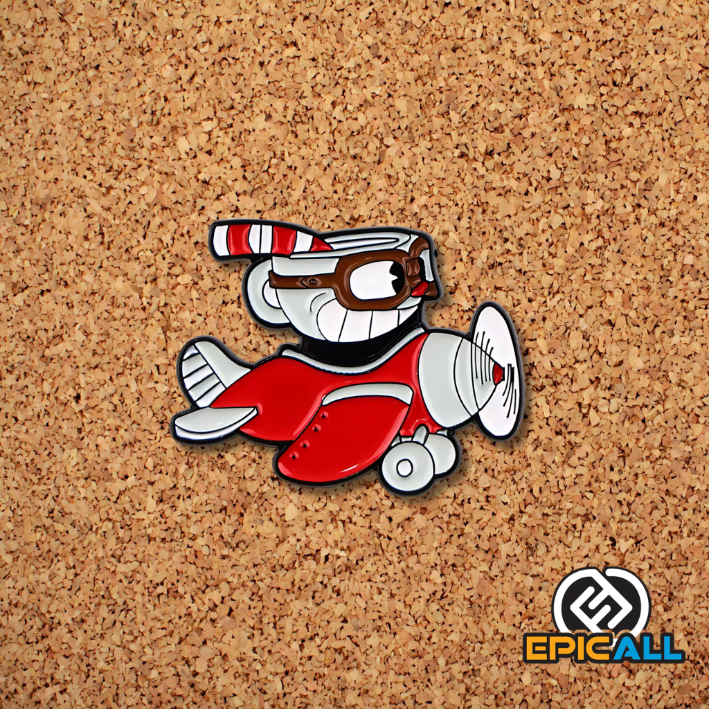 Pin metálico con la imagen de Cuphead, un personaje de videojuego en forma de taza, pilotando un avión rojo. El fondo del pin es blanco. El pin mide 3.8 centímetros de ancho y 3 centímetros de alto.