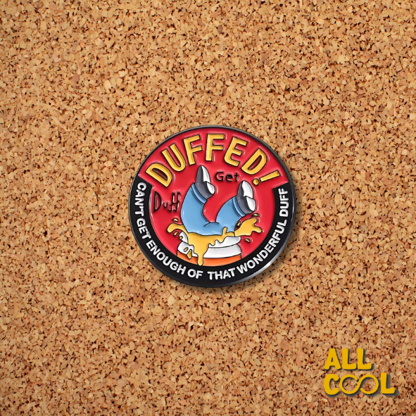 Pin redondo con una ilustración de Los Simpsons que dice ‘Duffed!’ y una imagen de homero denro de una lata de cerveza sobre un fondo rojo