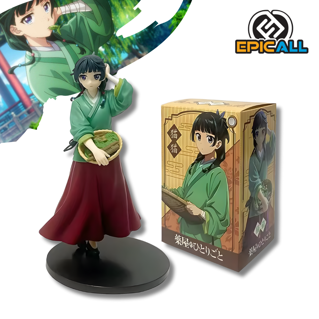 Una figura de estatua de Maomao del anime Diarios De La Boticaria. La figura viste una túnica verde y una falda roja larga, tiene el cabello oscuro recogido y sostiene una pequeña cesta tejida llena de verduras o hierbas con su mano derecha. Está de pie sobre una base circular negra.