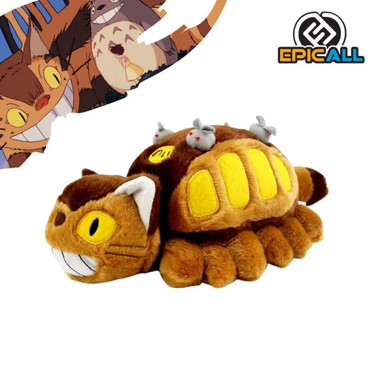 Un peluche de Gatobus, el autobús gato de la película de Studio Ghibli, Mi Vecino Totoro. El peluche es de color marrón y amarillo, con ojos grandes y redondos. Tiene una forma alargada y suave, y en su espalda lleva varios pequeños ratones.