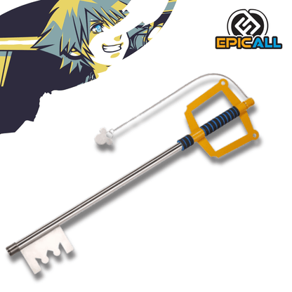 Réplica de la Keyblade Kingdom Key clásica de Kingdom Hearts, con hoja metálica plateada, guarda cuadrada de color amarillo brillante, empuñadura azul y negra, y su distintiva cadena con el llavero de la silueta del Rey Mickey.