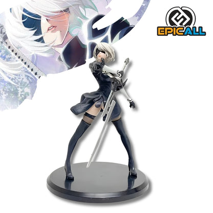 Figura coleccionable de PVC de 13 cm de altura de la androide 2B de NieR Automata en pose de combate dinámica, luciendo vestimenta gótica negra con bordados, visor visor de combate ciego, cabello corto platinado y sosteniendo su espada katana sobre una base circular negra.
