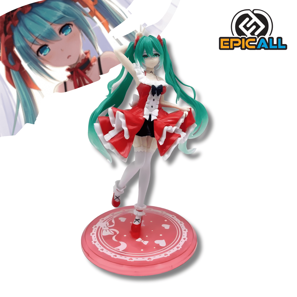 Una figura de estatua de Hatsune Miku con su largo cabello turquesa, de unos 18 cm de altura. Viste un vestido estilo Lolita corto, de color rojo con volantes blancos y un gran lazo negro en el cuello. La figura está en una pose de baile o levantando una mano, sobre una base redonda roja con decoración blanca.