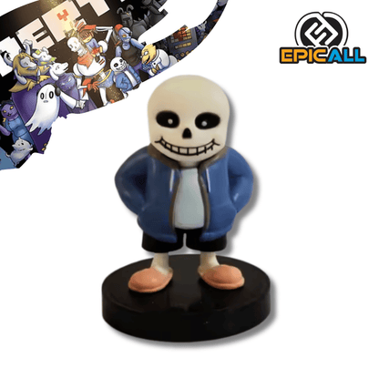 Una pequeña figura de estatua de Sans, el esqueleto del videojuego Undertale, de unos 7 cm de altura. El personaje tiene una cabeza de calavera blanca, ojos negros, viste una chaqueta azul con capucha, pantalones negros y pantuflas rosas, y está de pie sobre una base circular negra.