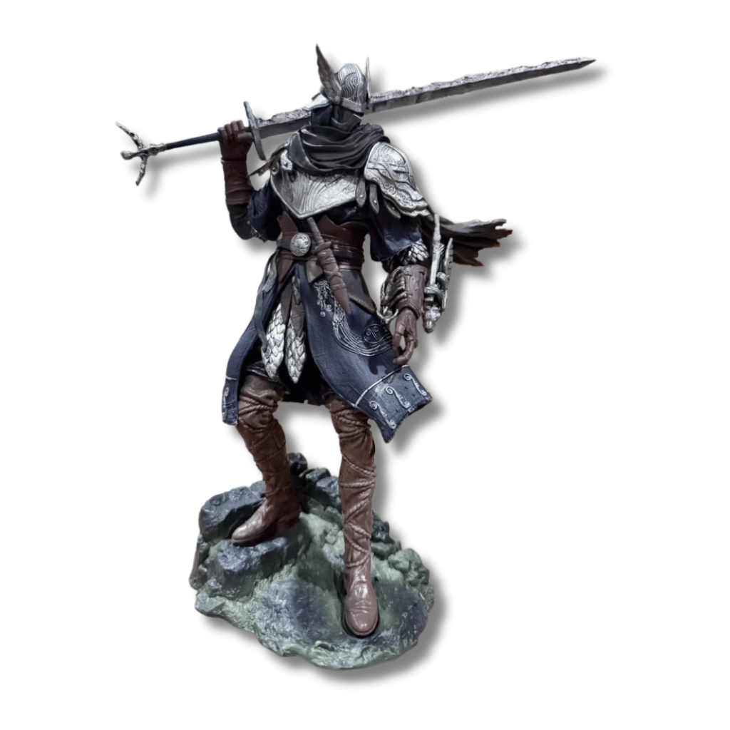 Estatua detallada del caballero Wylder de Elden Ring sobre una base de piedra, vistiendo una armadura ornamentada plateada y azul con una gran espada apoyada sobre su hombro.