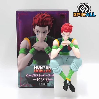 Foto de la figura de Hisoka sentada en una base y su caja.