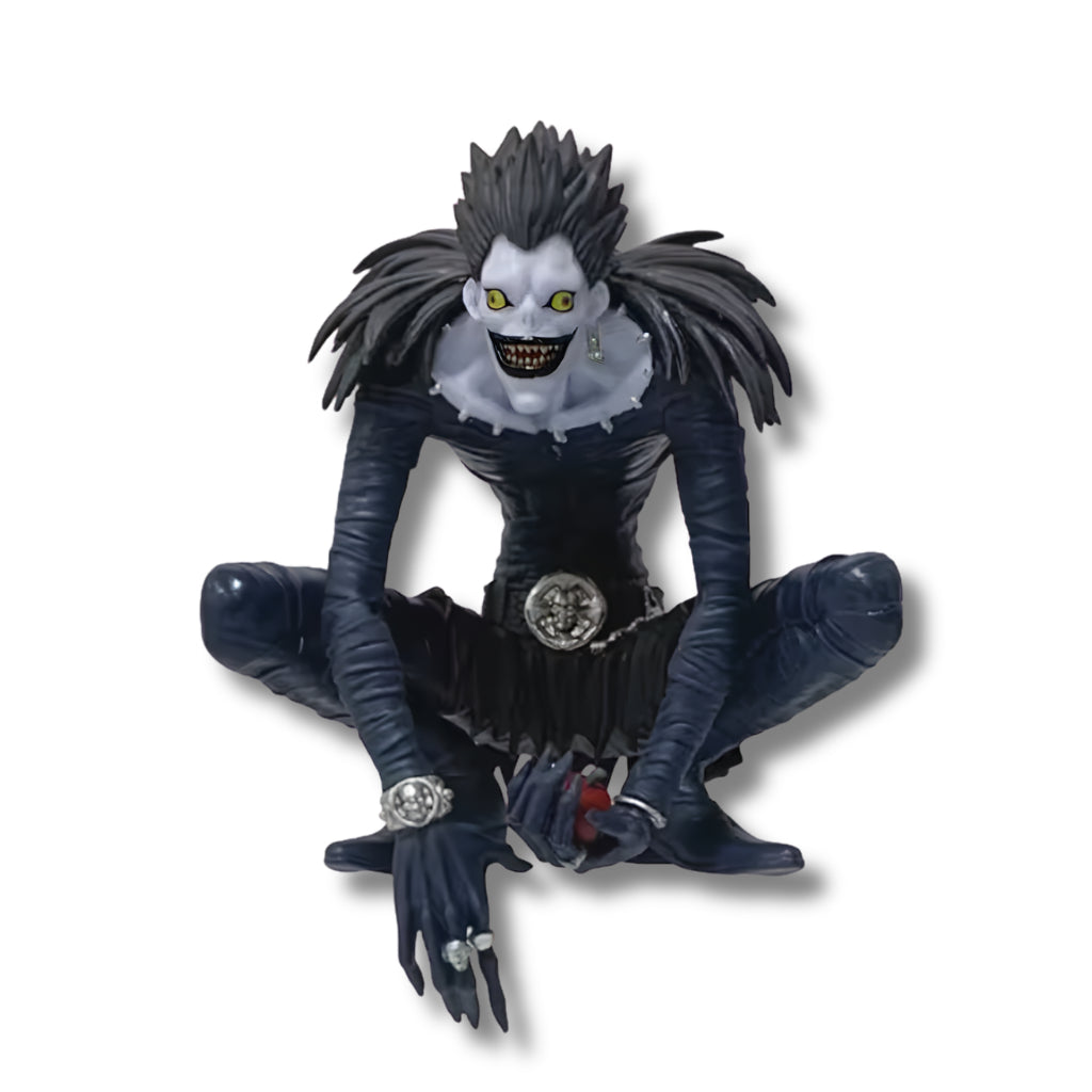 Figura coleccionable de PVC de 12 cm de altura del shinigami Ryuk de Death Note en pose agachada, luciendo piel pálida, ojos amarillos, sonrisa macabra, traje ajustado negro con plumas en los hombros y sosteniendo una manzana roja en sus manos.