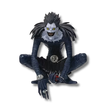Figura coleccionable de PVC de 12 cm de altura del shinigami Ryuk de Death Note en pose agachada, luciendo piel pálida, ojos amarillos, sonrisa macabra, traje ajustado negro con plumas en los hombros y sosteniendo una manzana roja en sus manos.