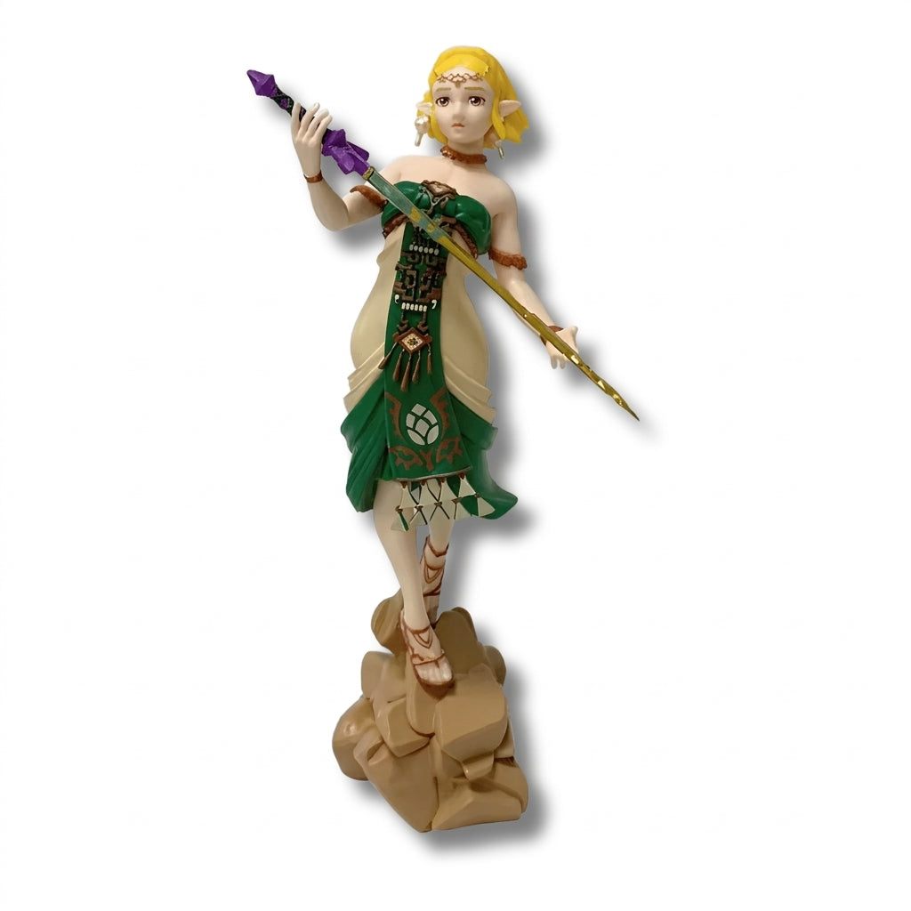 Figura coleccionable de PVC de 20 cm de altura de la Princesa Zelda con atuendo ceremonial de vestiduras verdes y crema con patrones zonnan, sosteniendo una espada estilizada y posando sobre una base temática rocosa.
