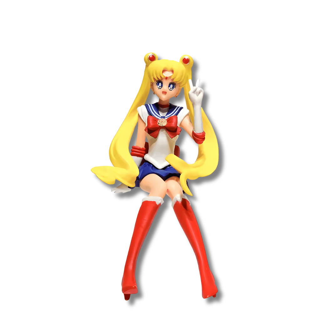 Una figura de estatua de Sailor Moon (Serena Tsukino), de unos 15 cm de altura, en su uniforme de marinera rojo, blanco y azul con botas rojas y coletas rubias largas. La figura está sentada y tiene una mano levantada haciendo el signo de la paz.