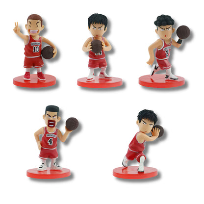 Set de 5 figuras coleccionable tipo gachapon con las alineaciones titulares del equipo Shohoku de Slam Dunk en estilo chibi: Hanamichi Sakuragi (#10), Kaede Rukawa (#11), Ryota Miyagi (#7), Takenori Akagi (#4) y Hisashi Mitsui (#14), vistiendo el uniforme rojo de básquetbol sobre bases circulares rojas.