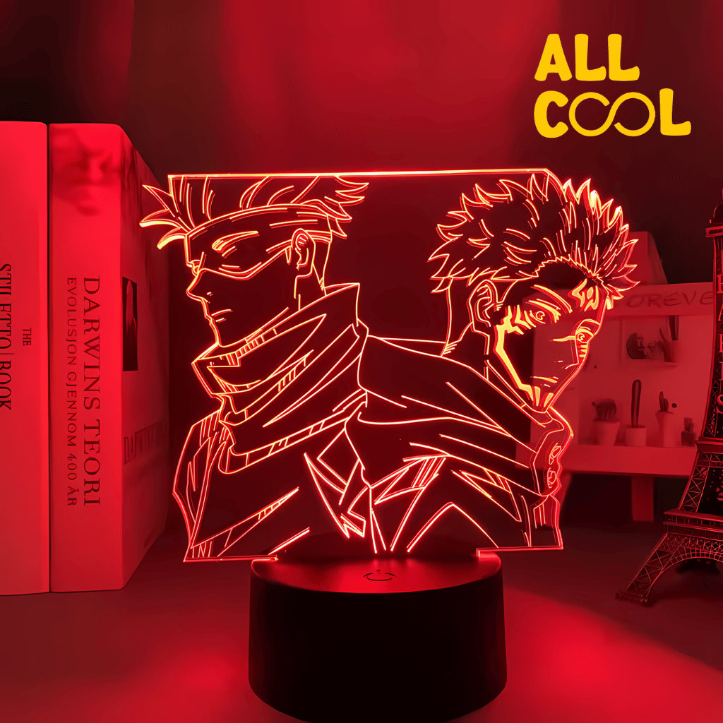Una lámpara LED con diseño 3D de Satoru Gojo y Sukuna, dos personajes del anime Jujutsu Kaisen. La imagen muestra a ambos personajes en una pose de combate, con un fondo oscuro. La lámpara tiene una base circular y emite una luz suave.