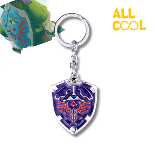 Un llavero metálico con la forma del Escudo de Hyrule, del videojuego The Legend of Zelda. El escudo es de color azul con detalles rojos y dorados. El llavero mide 10 cm de largo aproximadamente.