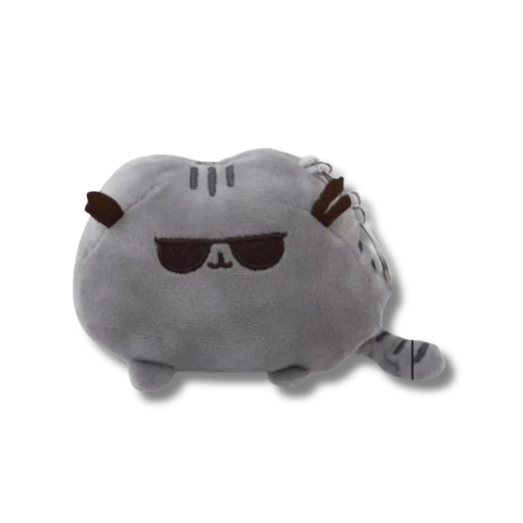 Llavero de peluche suave de Pusheen el gato en color gris con gafas de sol oscuras bordadas, orejas y cola a rayas, con argolla metálica en la parte posterior sobre fondo blanco.
